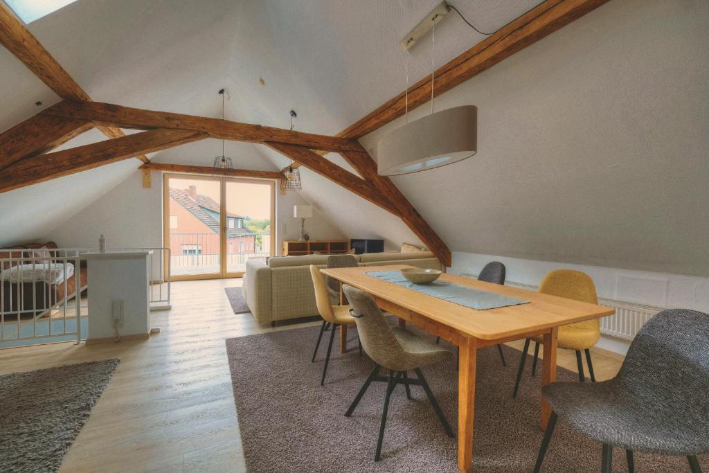 uma sala de estar com uma mesa de madeira e cadeiras em Mainloft em Hassfurt