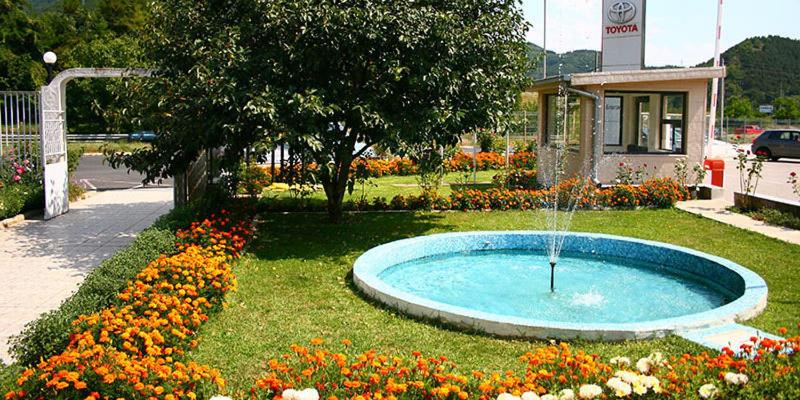a fountain in the middle of a park with flowers at Motel Monza in Blagoevgrad