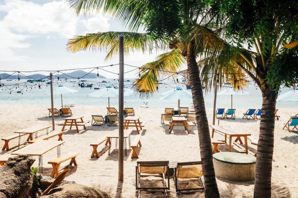 uma praia com cadeiras e mesas e palmeiras em Villa Đảo Hoa Vàng Cam Ranh - Venuestay em Cam Ranh