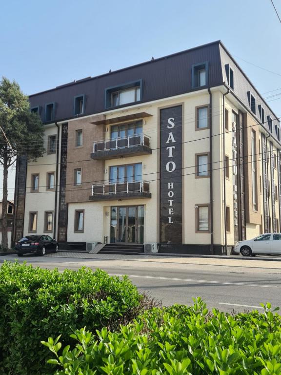 un bâtiment avec un panneau sur son côté dans l'établissement SATO HOTEL TASHKENT, à Tachkent
