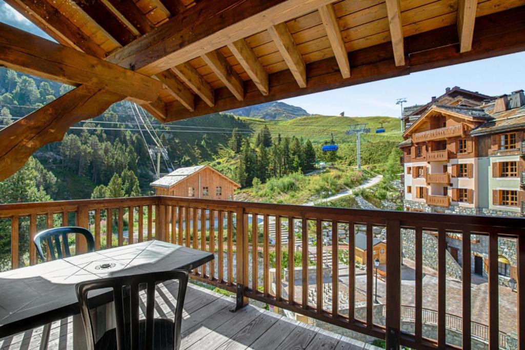 d'un balcon avec une table et une vue sur les montagnes. dans l'établissement Résidence Les Arcs 1950 Le Village - maeva Home - 3 Pièces 8 Personnes Prestige MAE-7198, à Bourg-Saint-Maurice