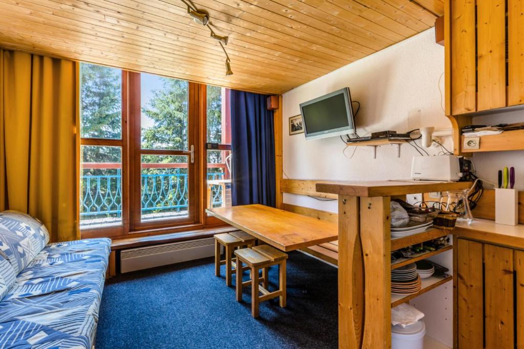 Cette chambre comprend un bureau, une table et un canapé. dans l'établissement Résidences quartier Charmettoger - maeva Home - 2 Pièces 6 Personnes Budget MAE-3506, à Arc 1800
