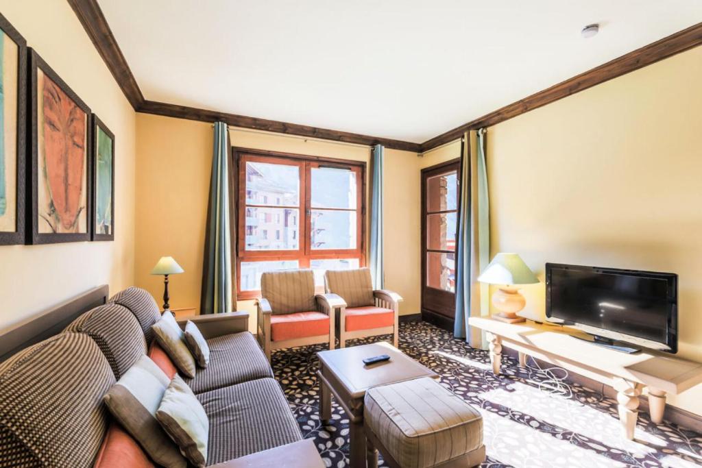 un salon avec un canapé et une télévision dans l'établissement Résidence Les Arcs 1950 Le Village - maeva Home - Appartement 2 pièces 4 personnes - Sélection MAE-3894, à Bourg-Saint-Maurice