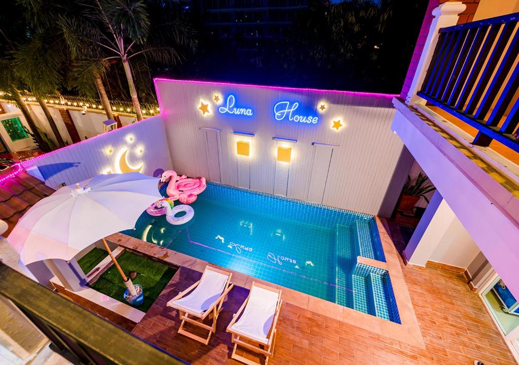 an overhead view of a pool with an umbrella and chairs at 4 Bedroom Town Villa With Private Pool in Pattaya South