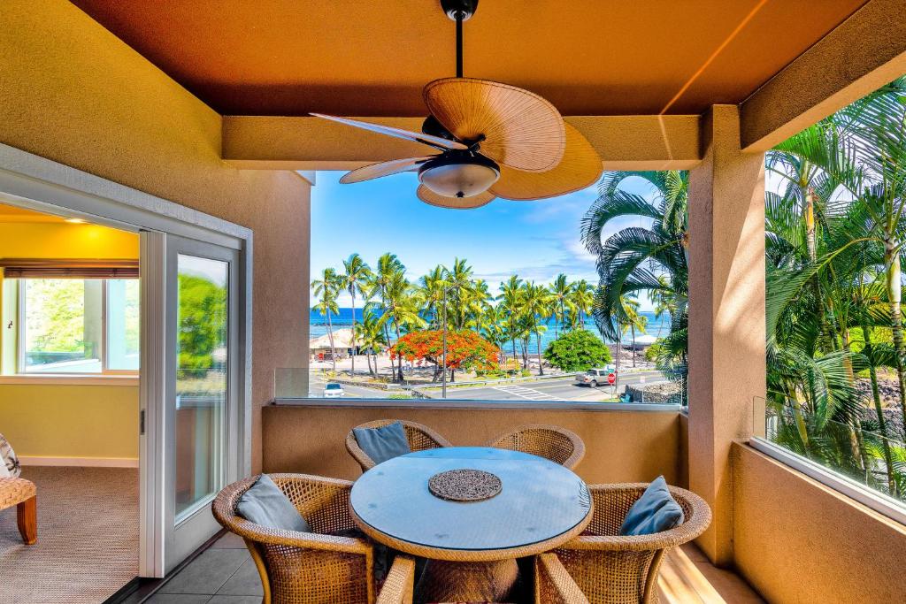 a balcony with a table and chairs and a view of the ocean at Kahalu'u Beach Villas 1-203 in Kailua-Kona