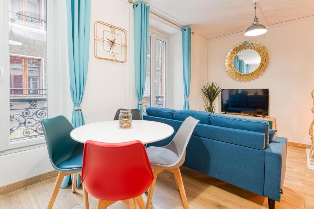 a living room with a blue couch and a table and chairs at Bien-être et bonheur au pied des Thermes in Allevard