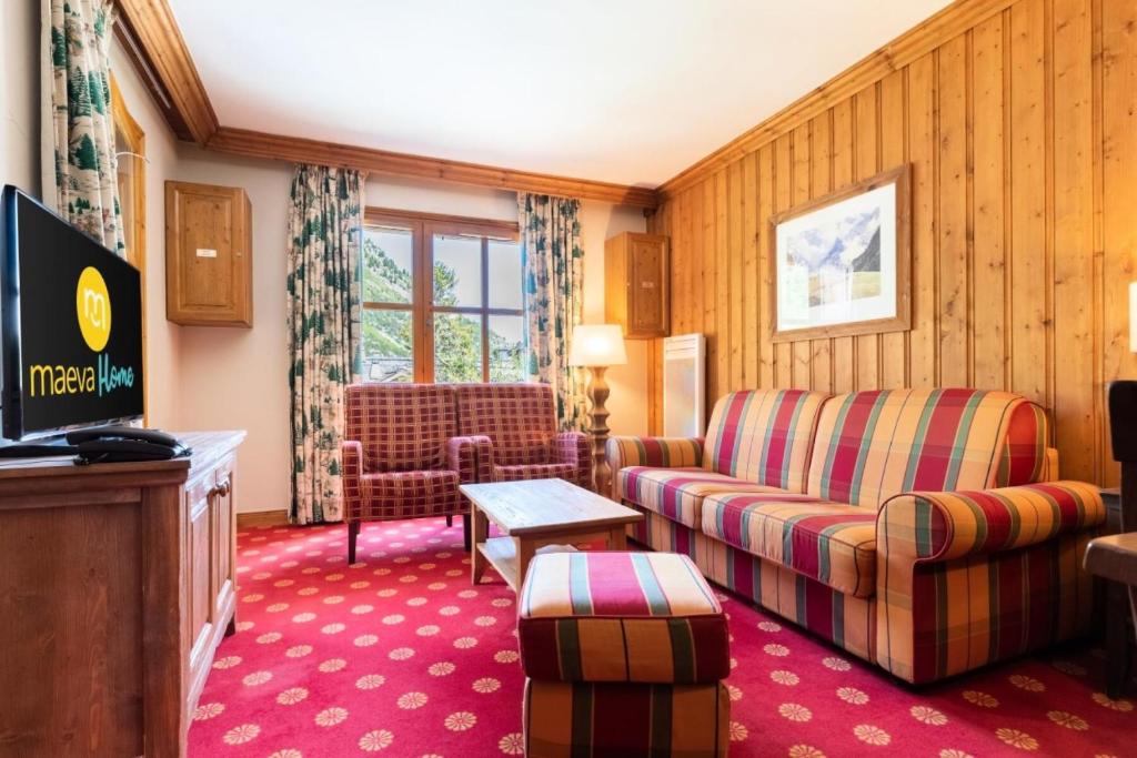 un salon avec un canapé et une télévision dans l'établissement Résidence Les Arcs 1950 Le Village - maeva Home - Appartement 3 Pièces 6 Personnes - Sélection MAE-7310, à Bourg-Saint-Maurice