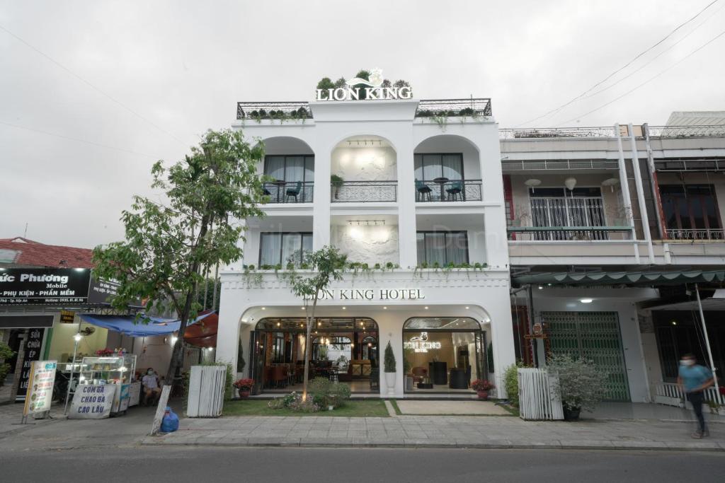 een wit gebouw met een winkel op straat bij Lion King Hotel in Hội An