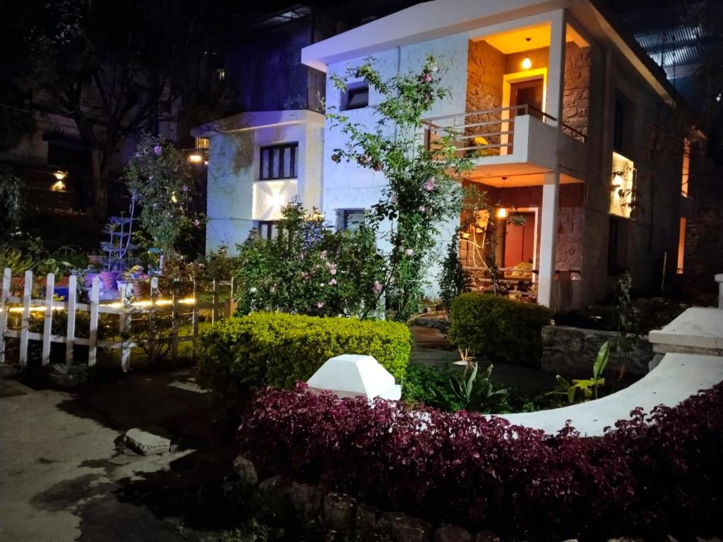 a house at night with flowers in front of it at Hotel Seven Roads in Kodaikānāl