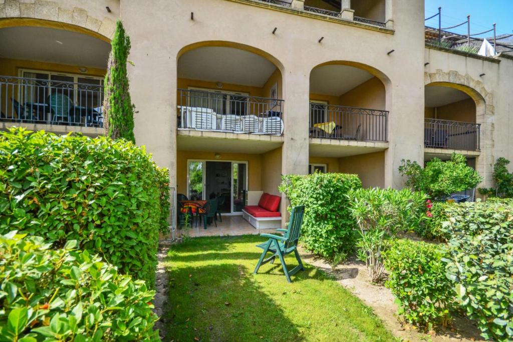 une maison avec une chaise verte dans la cour dans l'établissement Village Pont Royal en Provence - maeva Home - Studio 5 Personnes Selection MAE-4892, à Mallemort
