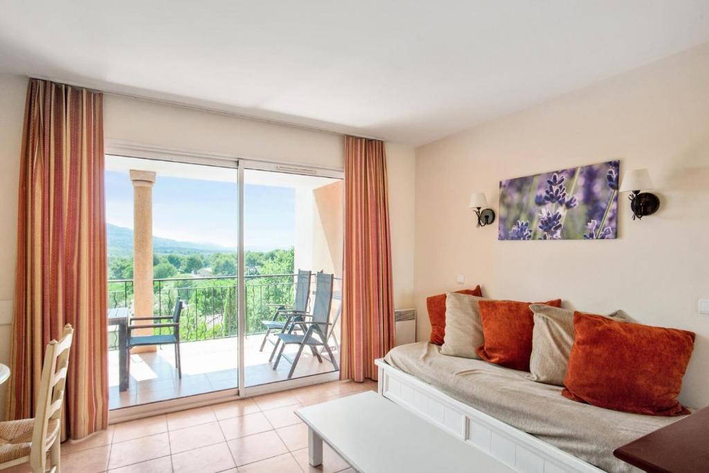 d'un salon avec un canapé et un balcon. dans l'établissement Village Pont Royal en Provence - maeva Home - 3 pièces 6 personnes Prestige MAE-6049, à Mallemort