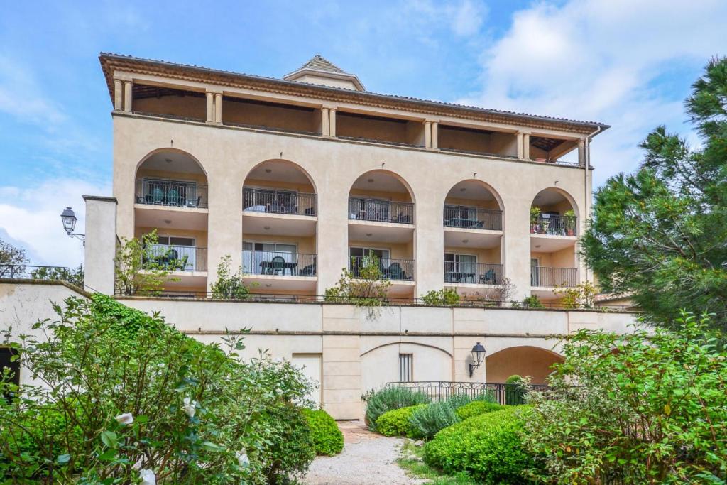 une vue extérieure d'un bâtiment avec des plantes dans l'établissement Village Pont Royal en Provence - maeva Home - Appartement 2 pièces 6 personnes Sélection MAE-7984, à Mallemort