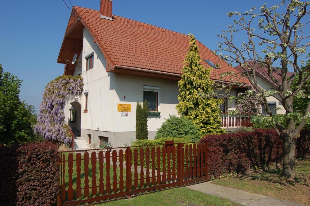 a house with a wooden fence in front of it at Szalai Vendégház in Cserszegtomaj