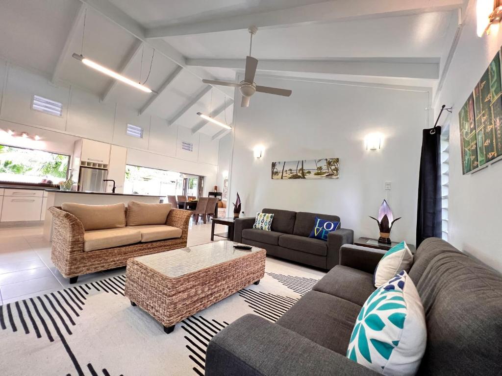 a living room with couches and a coffee table at Sina Pool Villa Rarotonga in Arorangi
