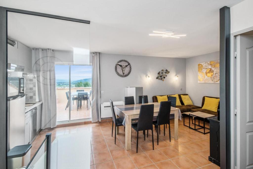 uma cozinha e sala de jantar com mesa e cadeiras em Village Pont Royal en Provence - maeva Home - Appartement duplexe moderne 4 Piè em Mallemort