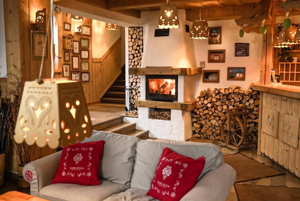 a living room with a couch and a fireplace at Tatra House Pensjonat in Zakopane