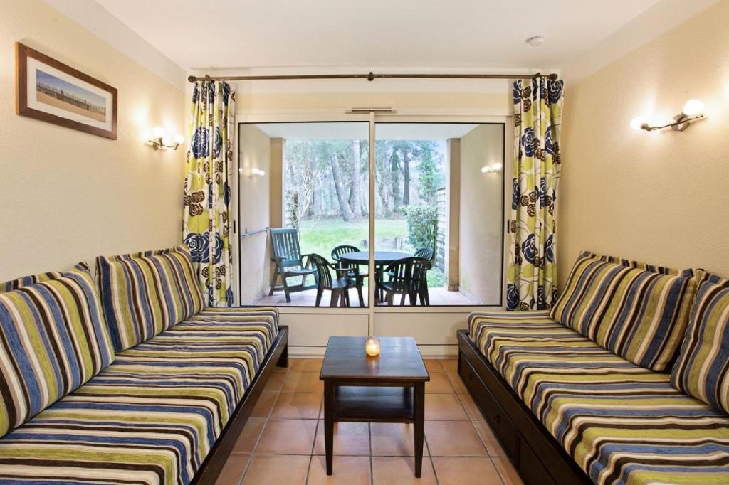 un salon avec deux canapés et une table dans l'établissement Le Domaine du Golf de Pinsolle - maeva Home - Appartement 2 pièces 5 personnes - Sélection MAE-7424, à Soustons