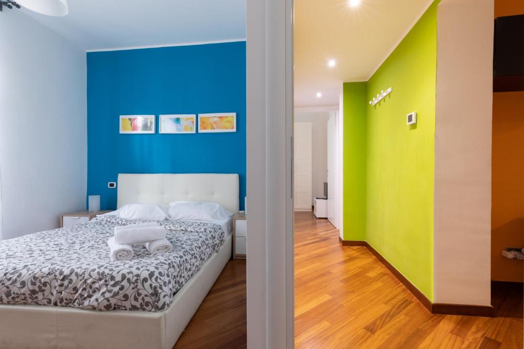 ein Schlafzimmer mit einer blauen und grünen Wand und einem Bett in der Unterkunft Borgo Vittorio St. Peter Apartments in Rom