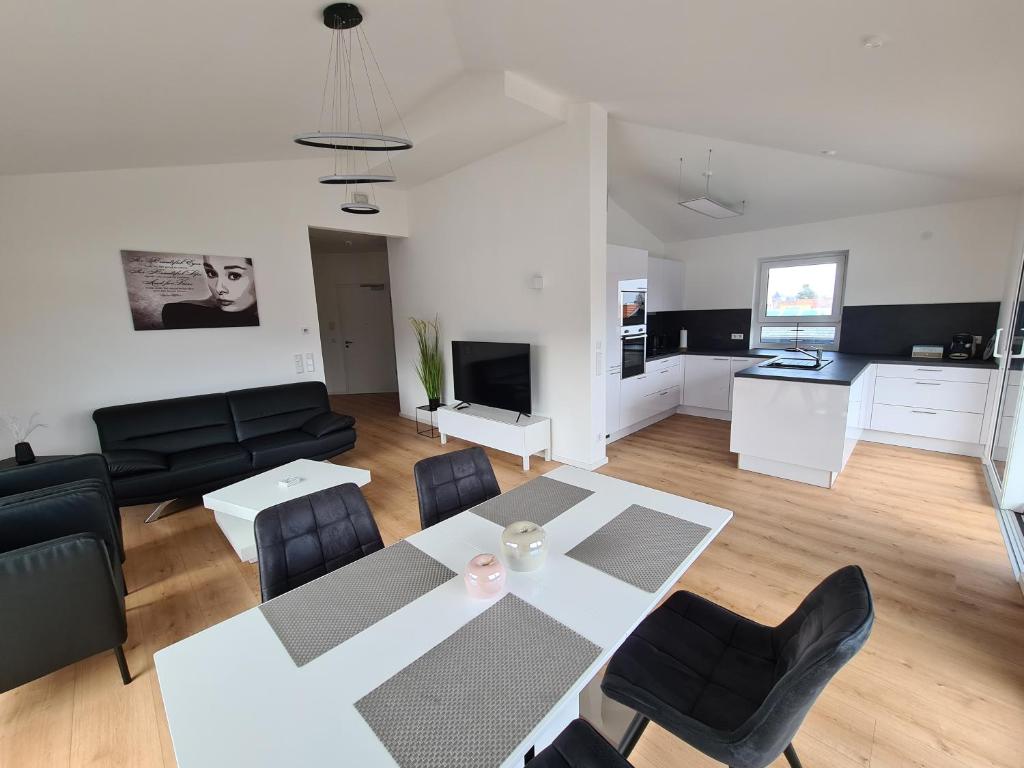 a living room with a white table and chairs at Panorama Penthouse in Füssen