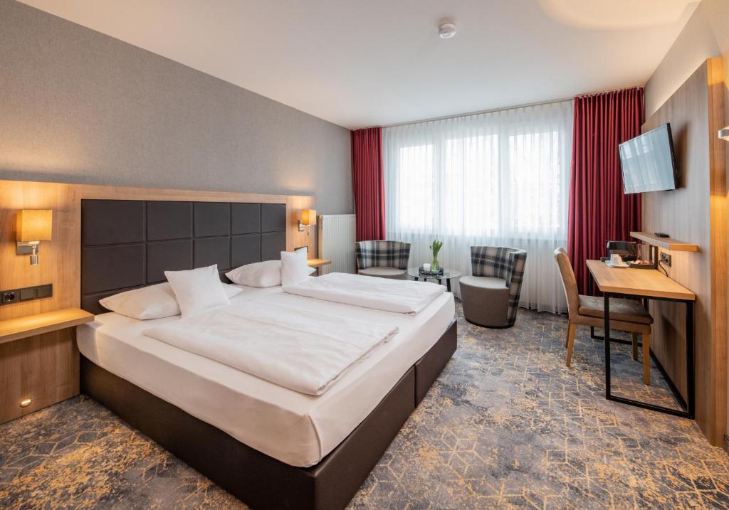 a hotel room with a large bed and a desk at Göbel's Sophien Hotel in Eisenach