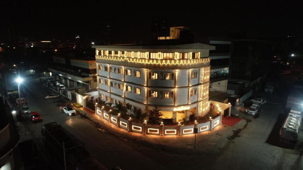 un edificio iluminado en una ciudad por la noche en The Royal Palace Hotel 400703, en Navi Mumbai