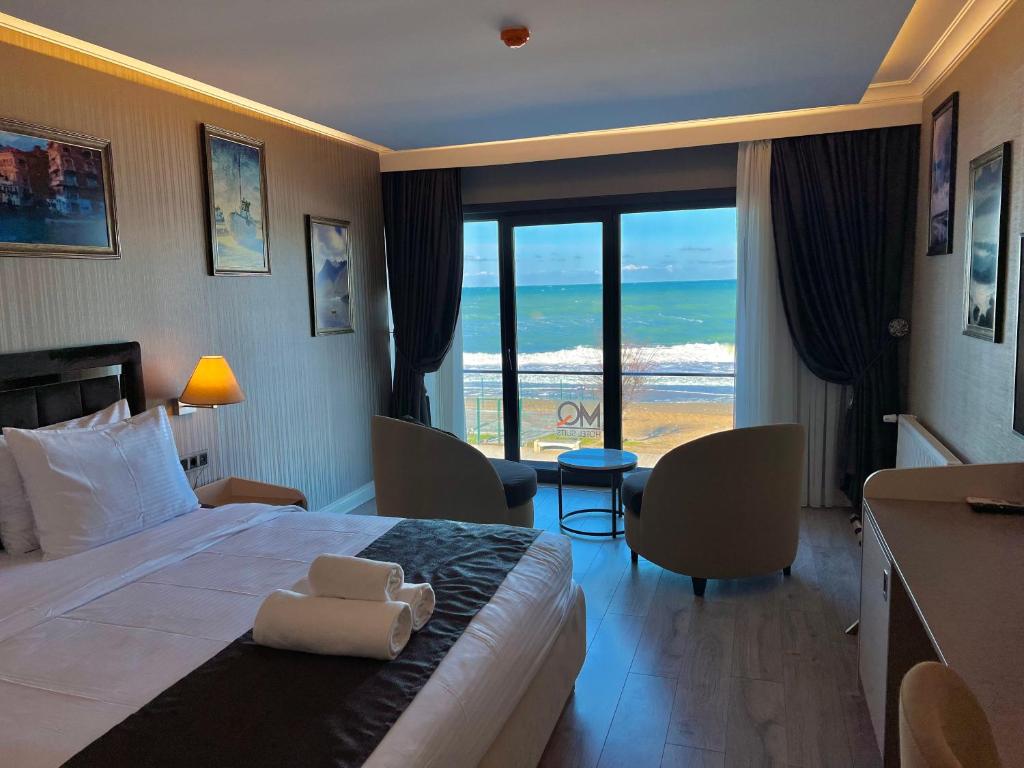 MQ Hotel Suites في Arnavutköy: غرفة فندقية بسرير وإطلالة على المحيط