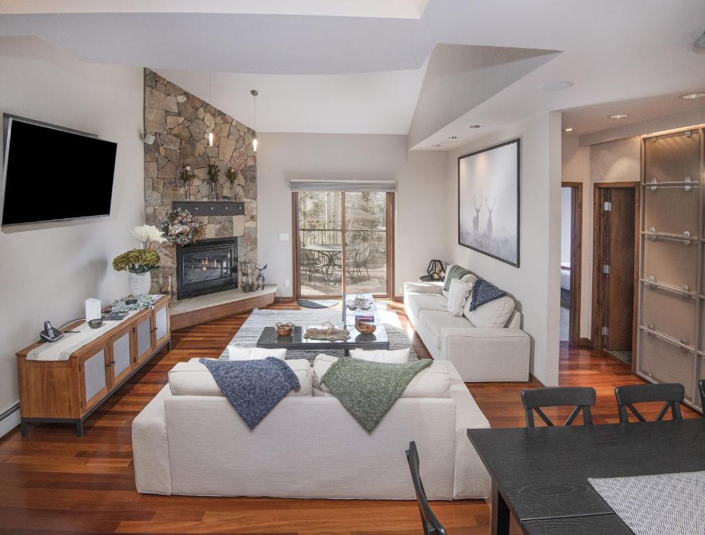 a living room with white furniture and a fireplace at Vail Point 7 townhouse in Vail