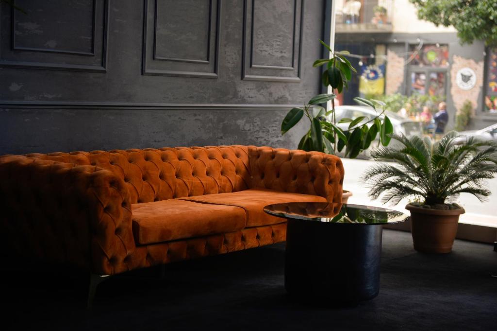 a brown couch in a room with a table at Aura Boutique Hotel in Batumi