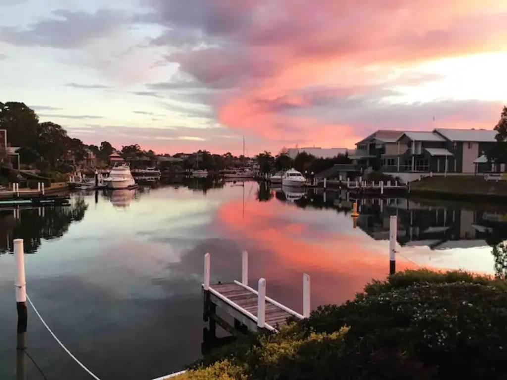 a marina at sunset with boats in the water at The View - Captains Cove Waterfront Resort in Paynesville