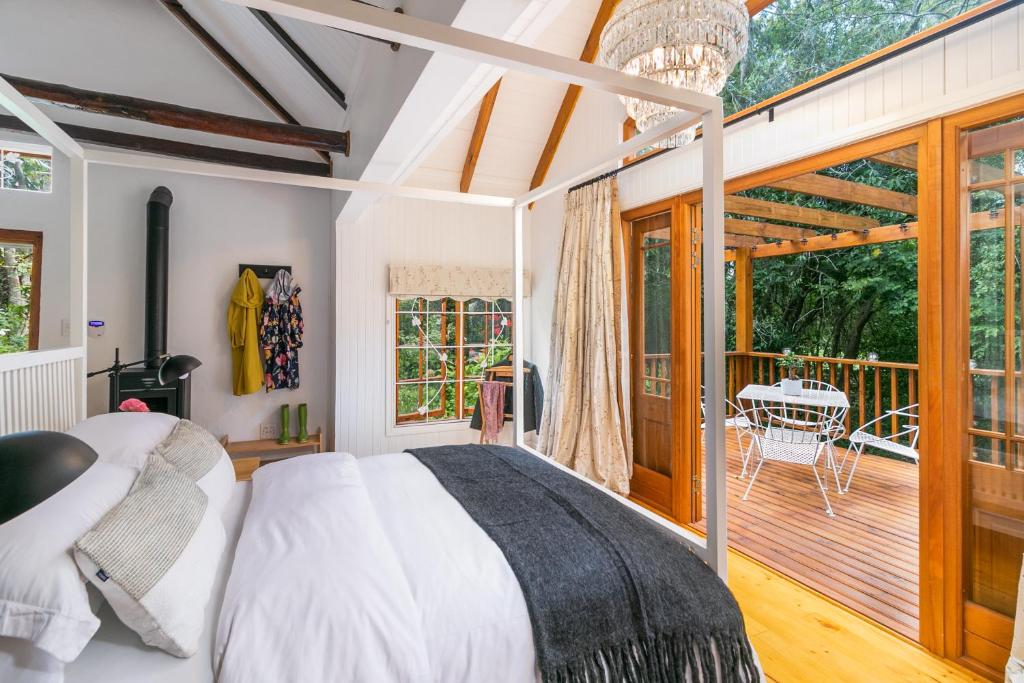a bedroom with a bed and a deck at Ganzvlei Manor Cottage in Knysna