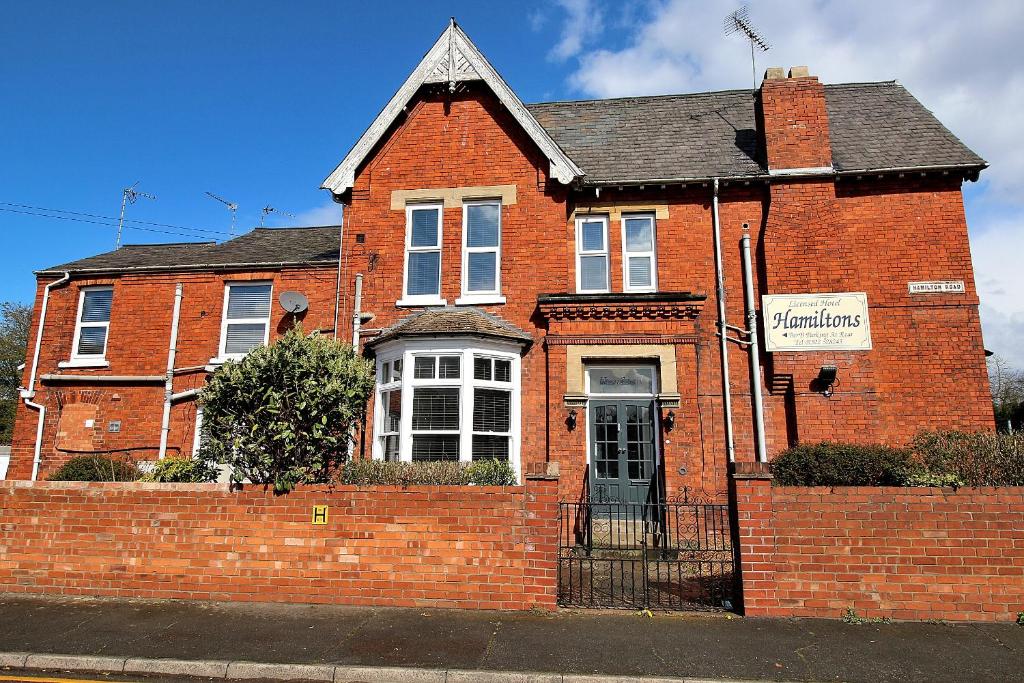 a red brick house with a sign on it at Hamilton Hotel in Lincoln