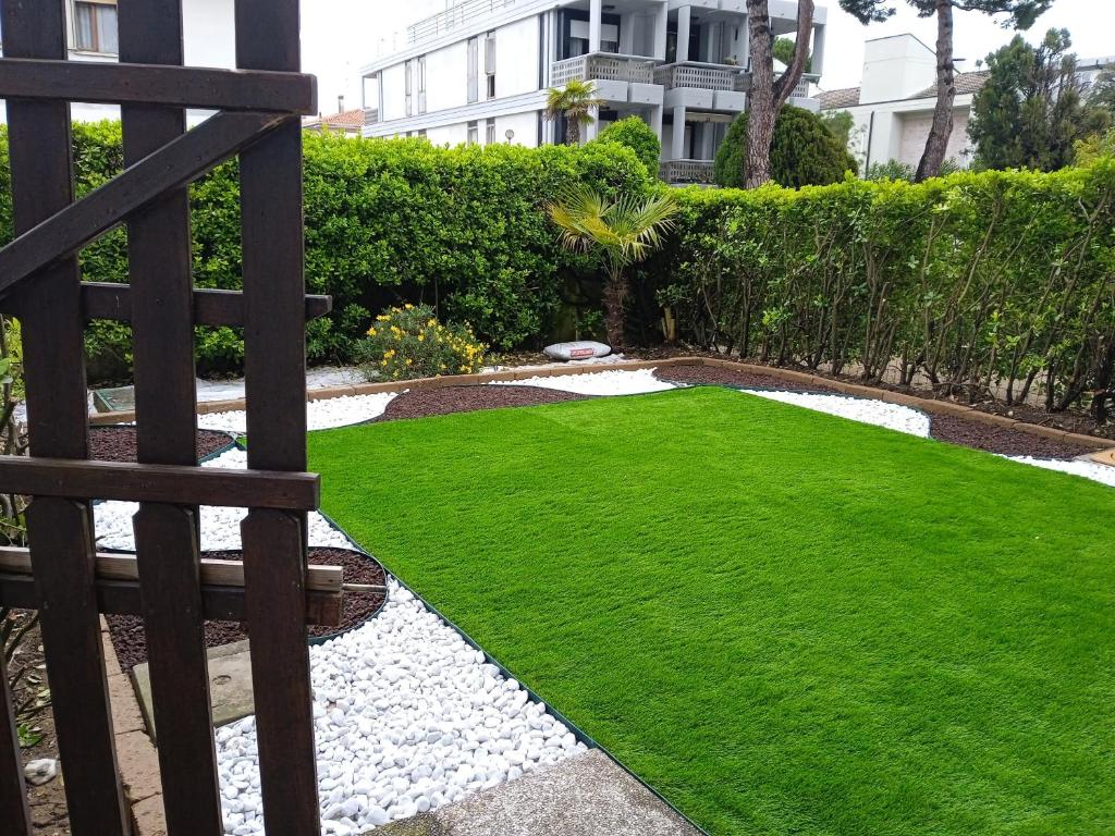 einen Garten mit grünem Gras und ein Gebäude in der Unterkunft Casa sul mare Adriatico in Cavallino-Treporti