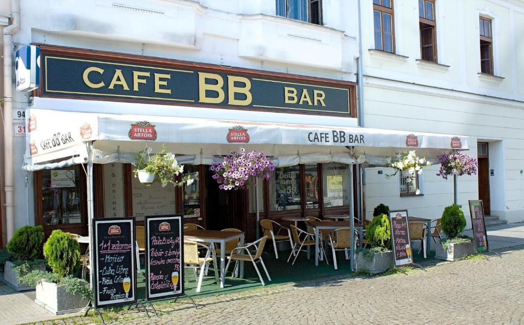 a cafe bar with tables and chairs in front of a building at Apartmany BB in Karviná