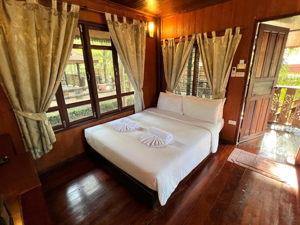 1 dormitorio con 1 cama con 2 almohadas en The Canal Garden Resort, en Ban Huai Sua