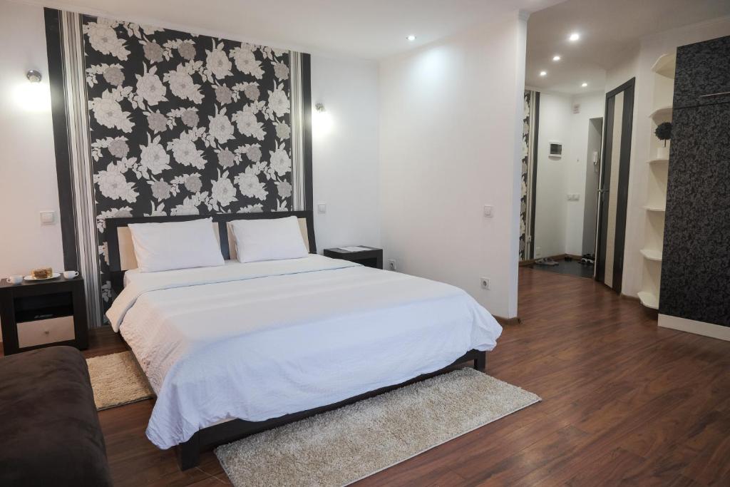 a bedroom with a white bed and a black and white wall at Apartament curat si confortabil in centru Str. Armeneasca 47 in Chişinău