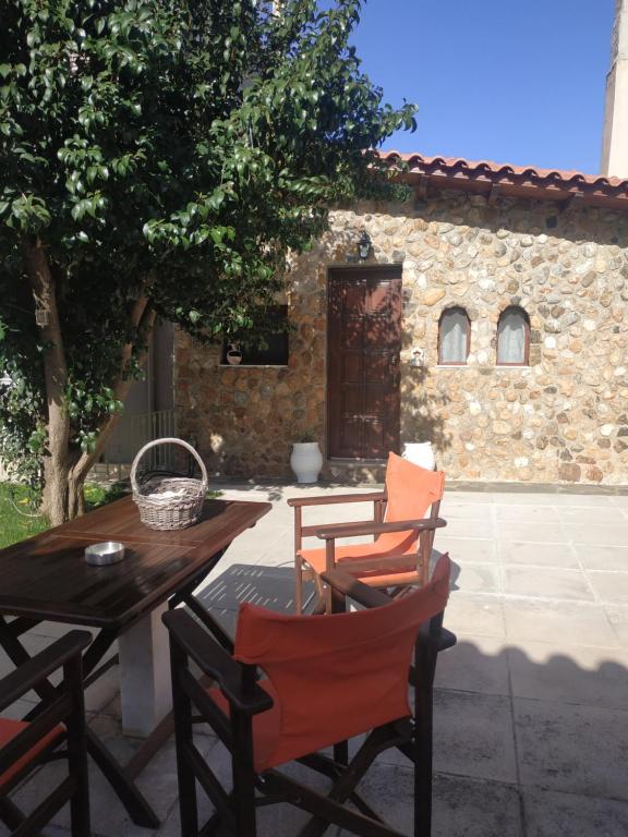 a patio with a table and chairs and a building at Garden's House in Spata