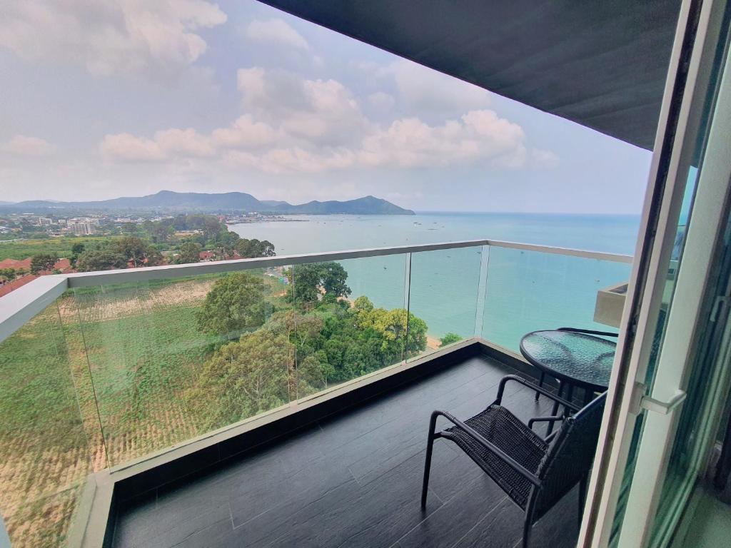 a balcony with a chair and a view of the ocean at Delmare Beachfront Bangsaray Premium Condominium in Bang Sare