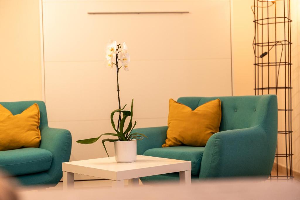 een woonkamer met twee blauwe stoelen en een tafel bij Suite - Sweet MayLeen in Merano