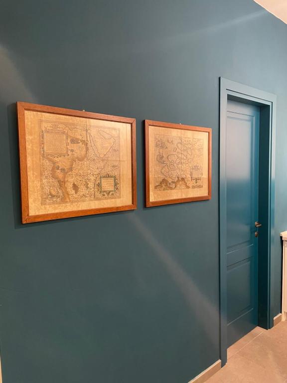 two framed maps on a wall next to a door at Isolotto Guest House in Porto Ercole