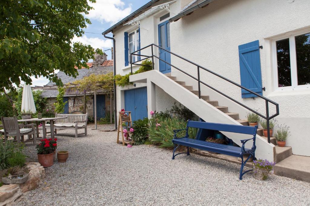 a blue bench in front of a house with a staircase at Apartment Fleur de Lys Bleue in Soudaine-Lavinadière