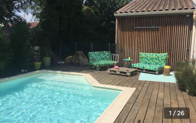 una piscina con 2 sillas y un edificio en Villa avec piscine privée au calme dans Toulouse, en Toulouse