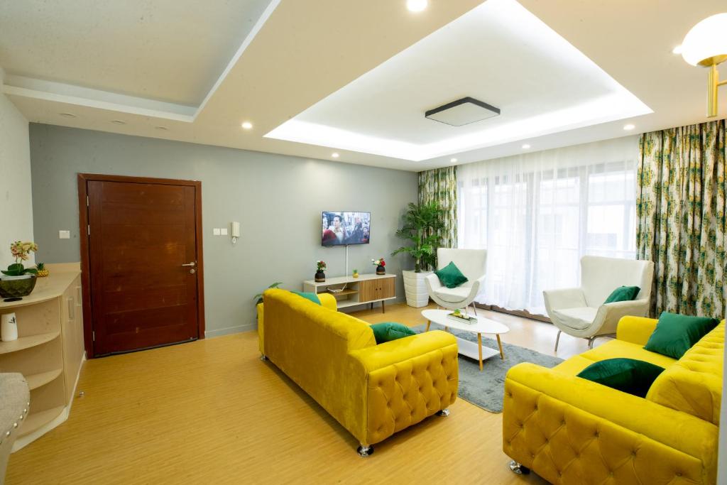 a living room with two yellow couches and a couch at COZY 3-BEDROOM SERVICED APARTMENT IN LAVINGTON BY COZY HOMEs in Nairobi