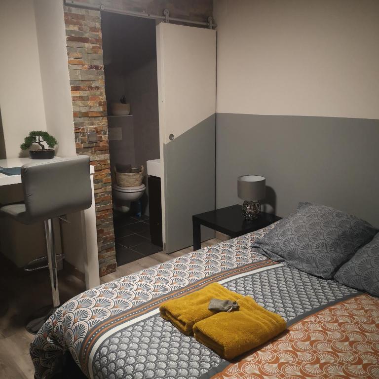 Un dormitorio con una cama con una manta amarilla. en studio hypercentre courteissade, en Aix-en-Provence