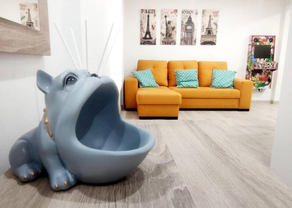 a living room with an elephant statue in front of a couch at - LUJO - Parking, Maquina Arcade, Wifi y Netflix in Oviedo