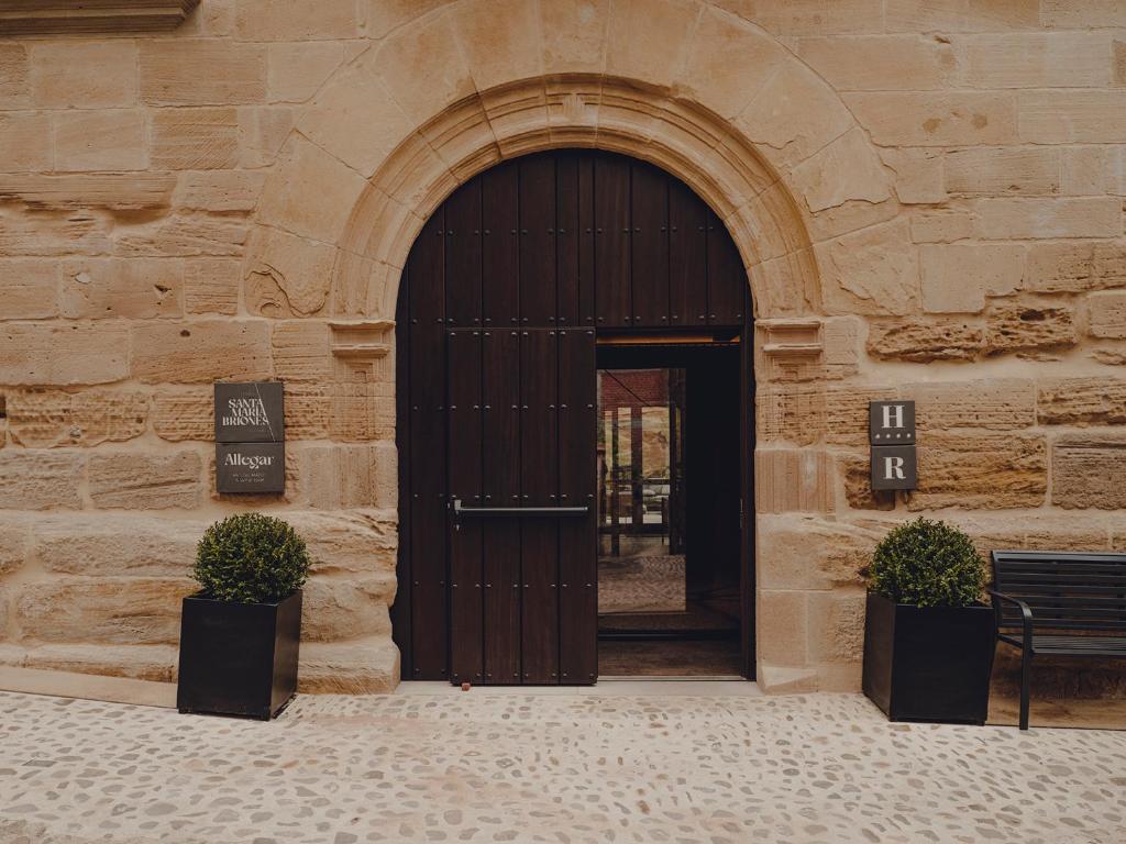 una entrada a un edificio con puerta de madera en Santa María Briones en Briones