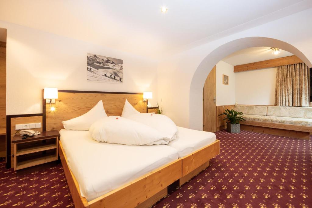 a bedroom with a large bed in a room at Hotel Garni Tyola in Ischgl