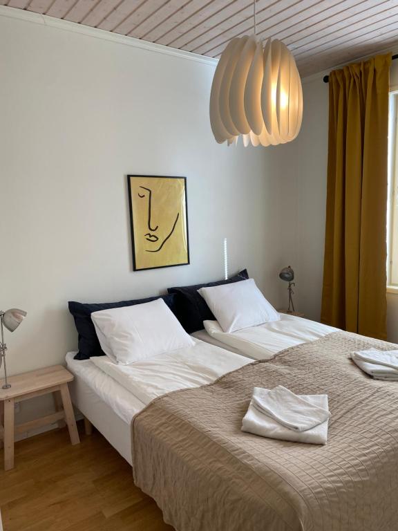 a bedroom with a large bed and a chandelier at Stava Mosters in Mariehamn