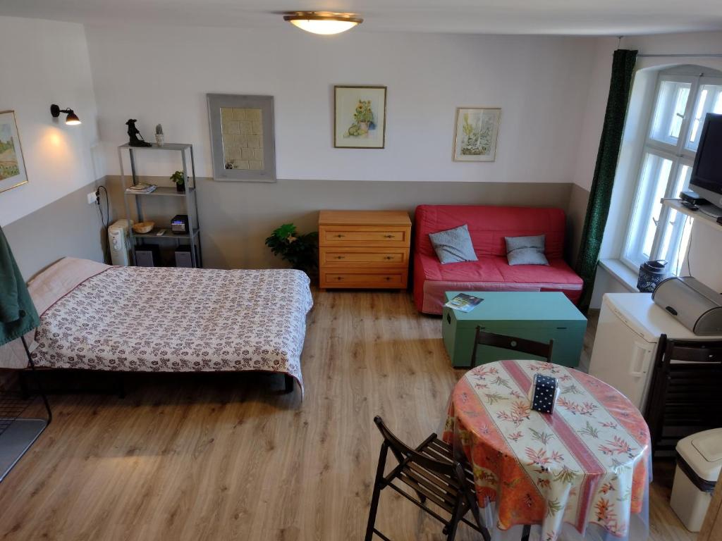 1 dormitorio con 2 camas y sofá rojo en Sudety hut, en Podgórzyn