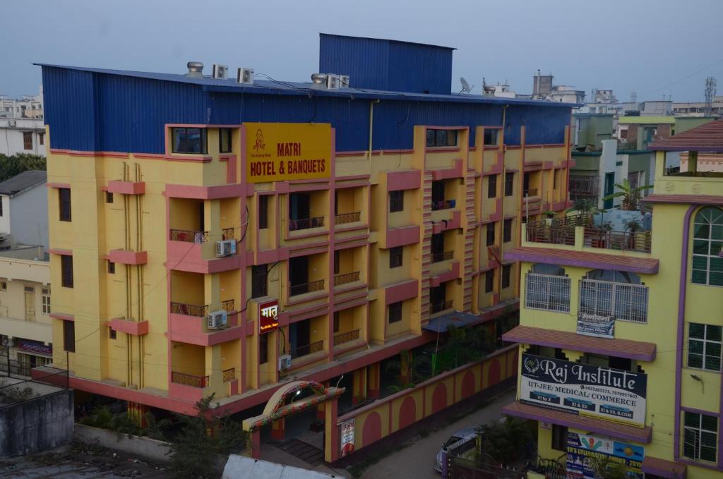 a yellow and blue building with a sign on it at Matri Hotel & Banquets in Patna