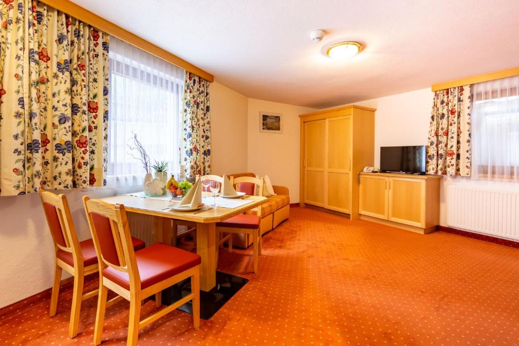jadalnia ze stołem i krzesłami w obiekcie Hotel Garni Tyola w mieście Ischgl